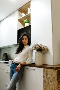 Mutfakta oturan neşeli genç bayan.