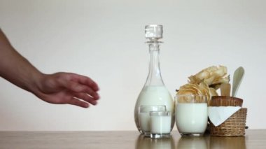 Yavaş Çeken Adam soldan ahşap masaya bir bardak süt koyuyor. Beyaz arkaplan kopyalama alanı