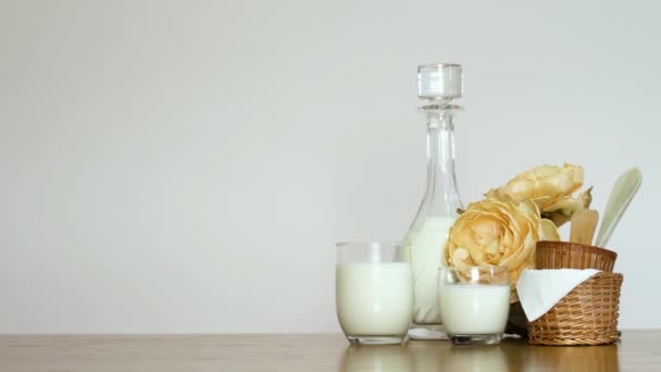 4K Man laat een glas melk achter op een houten tafel van rechts. Witte achtergrond kopieer ruimte — Stockvideo