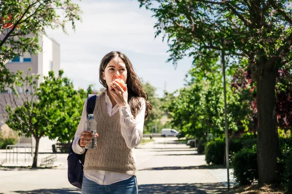 大学女生在校园里吃苹果 回大学去 — 图库照片