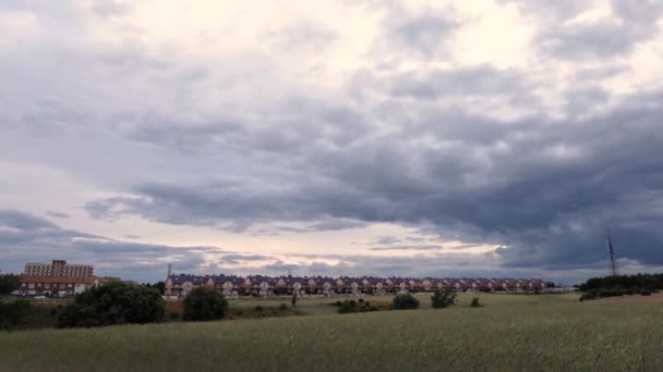 Zeitraffer Eines Bewölkten Sonnenuntergangs Über Einem Weizenfeld Und Häusern Hintergrund — Stockvideo