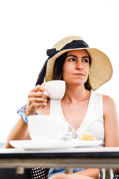 Vertical portrait of young hispanic woman drinking coffee with serious face