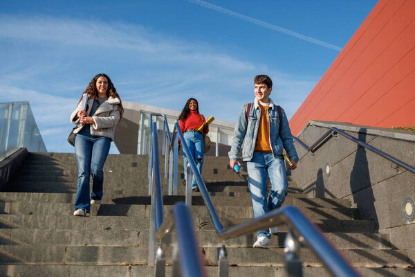 Multiethnic students walking downstairs on college campus