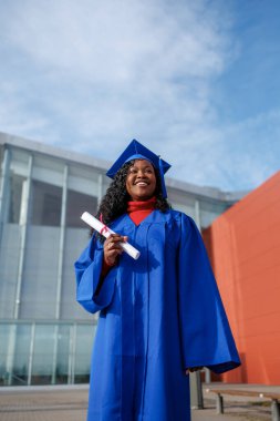 Mezuniyet diplomasını kutlayan mutlu siyah kadın öğrenci.
