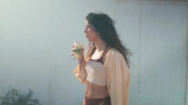 Genç mutlu kadın dışarıda mojito içiyor.