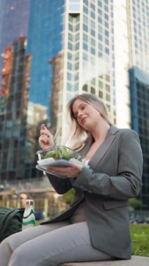 İş kadını dışarıda sağlıklı salata yiyor.