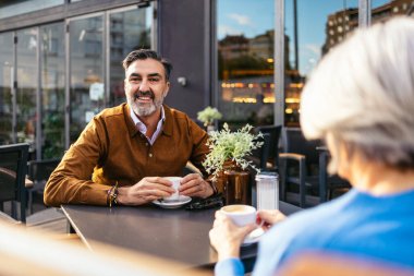 Kahvenin tadını çıkartan kıdemli bir adam.