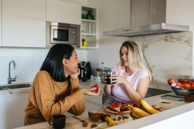 Kahvaltının tadını çıkaran gülümseyen kadınlar.