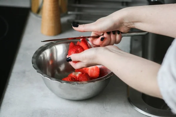 slicing strawberries into a bowl