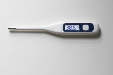 Dijital termometre, beyaz arkaplanda 38,5 derece izole olduğunu gösteriyor.