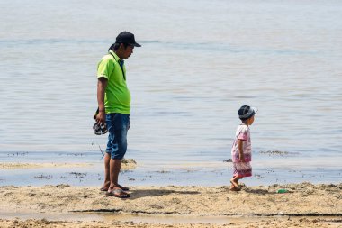 Kasuari Burnu, Sorong, Batı Papua, Endonezya, 22 Ağustos 2021. Bir baba plajda oynayan çocuğuna eşlik eder..