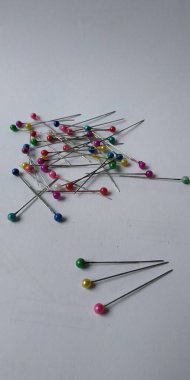 Beyaz arkaplanı olan bir toplu iğne