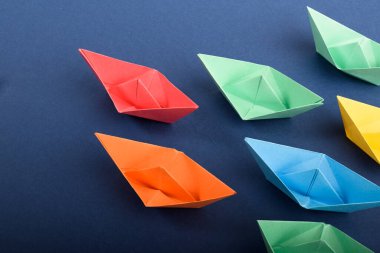 Bir grup koyu mavi renkli kağıt tekne. Takım çalışması, liderlik kavramı.