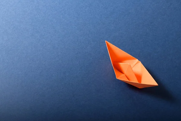 Barco de papel naranja solitario en azul profundo. — Foto de Stock