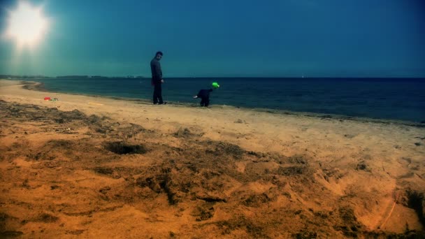 Vater und kleiner Junge spielen am Strand — Stockvideo