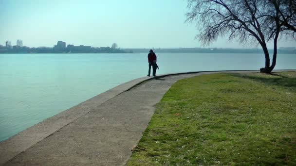 Madre y niño dando un paseo cerca del lago — Vídeo de stock