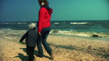 Anne ve çocuk sahilde çalıştıran