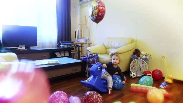 Малыш в окружении игрушек — стоковое видео