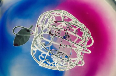 Beyaz elma telden yapılmış, cam üzerinde, arka plandaki suda boyalı.