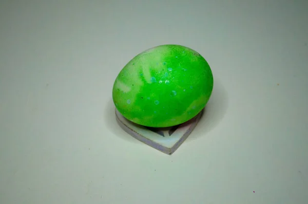 Beyaz bir tezgahta, beyaz bir masada yeşil bir yumurta.