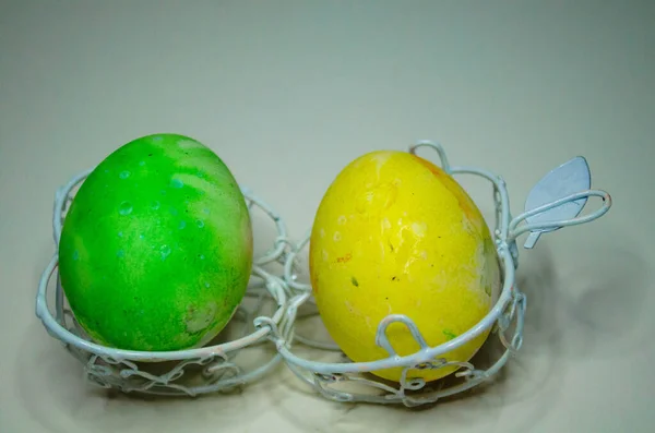 Beyaz bir tel üzerinde iki renkli yumurta.