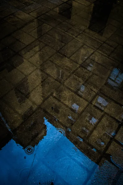 古い建物はタイルの上の水たまりに映し出され ロイヤリティフリーのストック写真