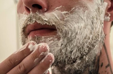 Adam sakalını kesiyor.