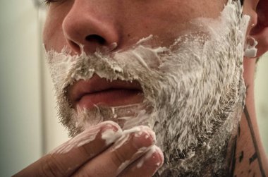 Adam sakalını kesiyor.