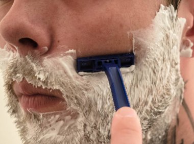 Adam sakalını kesiyor.