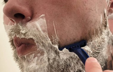 Adam sakalını kesiyor.