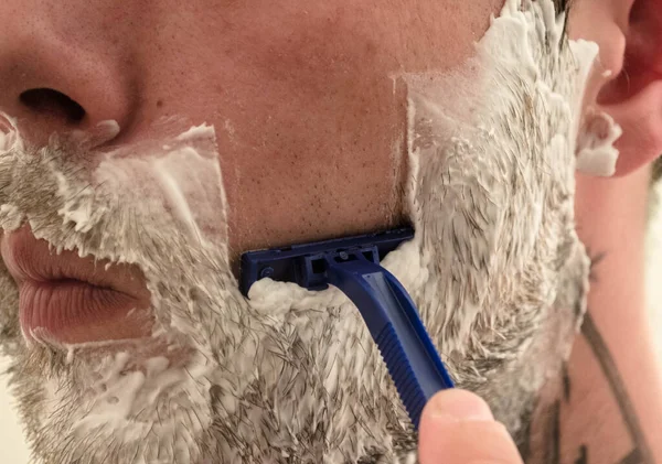 Adam sakalını kesiyor.