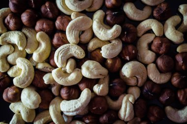 Fındık ve fındık karışımı, karanlık bir yüzeyde fotoğraf.