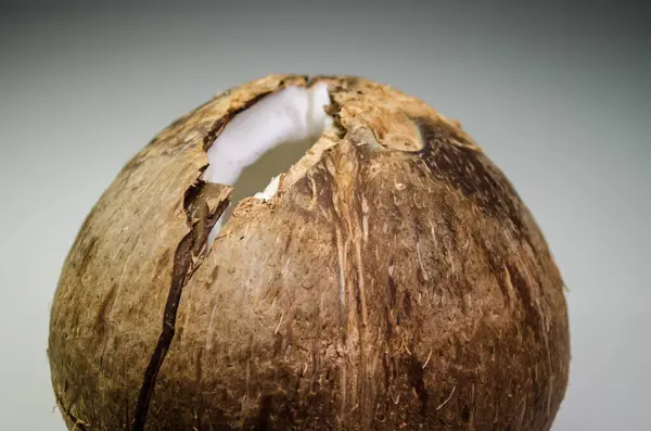 Popraskaný Kokos Leží Bílém Stole — Stock fotografie