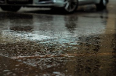 Yere yağmur damlıyor, yerde su birikintisi var.