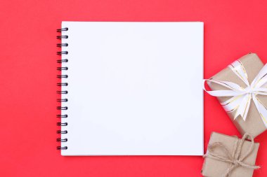 Kırmızı arkaplan ve hediye kutuları hakkındaki yazılar için boş notlar.