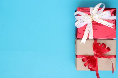 Kırmızı ve kahverengi hediye paketi mavi kağıt üzerinde Noel konsepti