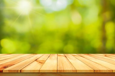 Tasarımın için yeşil arka planı olan ahşap masa.