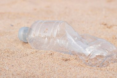 Plastik şişeler, kumdaki çöpler.