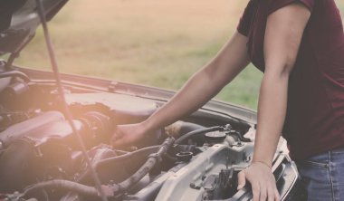 Arabanın motorunu kontrol eden kız.