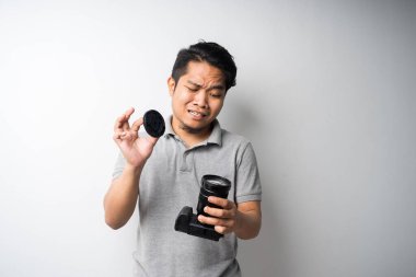 Genç Asyalı adam, DSR ya da aynasız kamerayla yüz ifadesini takınıyor. Fotoğraf, yaratıcı endüstri. İzole seçici odak.