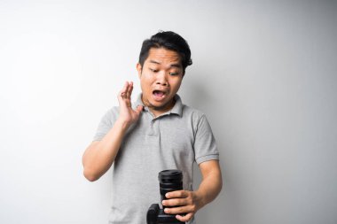 Genç Asyalı adam, DSR ya da aynasız kamerayla yüz ifadesini takınıyor. Fotoğraf, yaratıcı endüstri. İzole seçici odak.