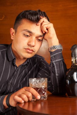 Düşünceli genç erkek alkol içiyor.