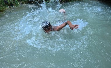 Boru hattında sızıntı var. Ondan sonra çocuklar kavurucu sıcak yaz mevsiminde yüzme havuzu gibi eğlendiler. Gurgaon, Haryana, Hindistan. 08-06-2021.