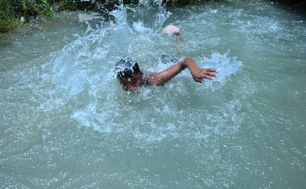 Boru hattında sızıntı var. Ondan sonra çocuklar kavurucu sıcak yaz mevsiminde yüzme havuzu gibi eğlendiler. Gurgaon, Haryana, Hindistan. 08-06-2021.