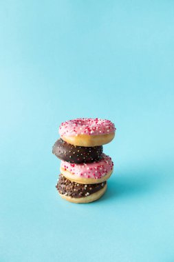 Çilekli ve çikolata parçacıklı donut. Pastel cyan b