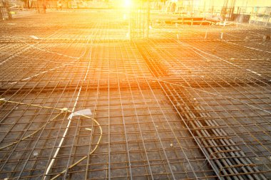 İnşaat alanında beton döşeme için takviye metal iskeleti yapan işçiler