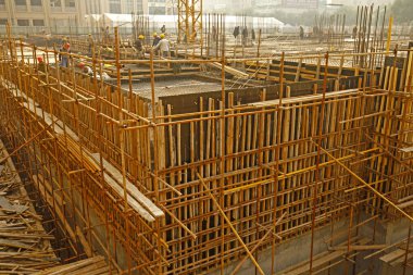 İnşaat alanında beton döşeme için takviye metal iskeleti yapan işçiler