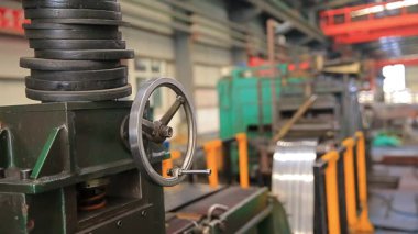 Çelik fabrikası atölyesinde mekanik ekipmanlar çalışıyor.