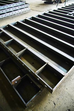 Çelik yapı atölyesindeki yay şekilli bileşenler ayrılmıştır ve kavisli çelik plakalar kubbeler ve kemerli köprüler gibi özel şekilli çelik yapıların çekirdek hammaddeleridir..