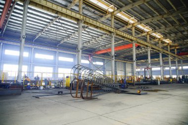 Çelik yapı atölyesindeki yay şekilli bileşenler ayrılmıştır ve kavisli çelik plakalar kubbeler ve kemerli köprüler gibi özel şekilli çelik yapıların çekirdek hammaddeleridir..